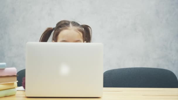 Πορτρέτο της ευτυχισμένη smart χαριτωμένο κορίτσι που κάθεται με στοίβα βιβλίων και φορητό υπολογιστή στο τραπέζι, αντίγραφο χώρου. Εκπαίδευση και ανάπτυξη της έννοιας — Αρχείο Βίντεο