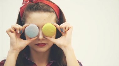Güzel mutlu sevimli genç güzel kadın kek macaroons sweeties arkasında gözlerini gizleme.