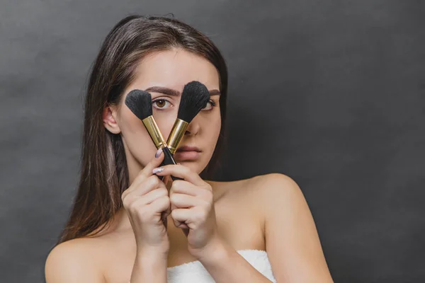Close up portrait of young gorgeous brunette girl with makeup brushes. — Stock Photo, Image