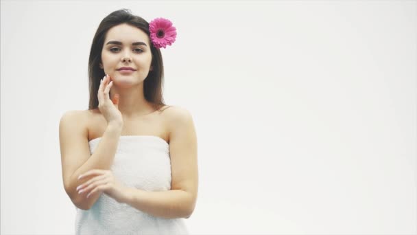 Das Konzept der Hautpflege, ein junges schönes Mädchen mit einer sauberen, glatten Haut, ein weißes Handtuch auf dem Kopf. — Stockvideo