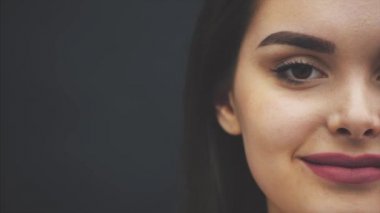 Mükemmel makyaj ile Güzellik esmer kadın. Güzel bir profesyonel makyaj tatili. Kırmızı dudaklar, mükemmel kaşlar. Bir kız yüzünün güzelliği karanlık bir arka plan üzerinde izole.