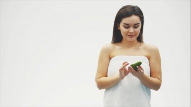 Beyaz arka planda makyajlı gülümseyen yeşil gözlü bir kadının yakın çekim fotoğrafı. Model kameraya bakarak avokado cilt yükselterek avokado cilt faydalarını göstermektedir.