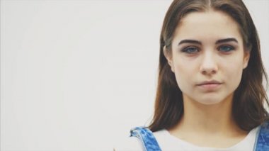 Büyük mavi gözleri ile Sevecen genç kadın hava öpücük darbeler, o rahat giysiler giymiş, doğal makyaj var.
