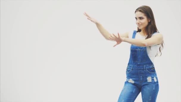 Heureuse jeune fille énergique insouciante avec des cheveux ondulés dansant danses occidentales et pointant quelque chose . — Video