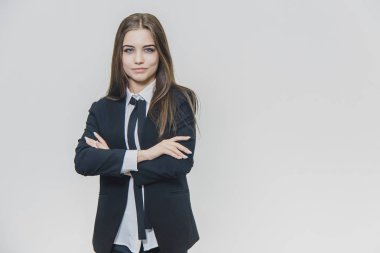 Sevimli kendine güvenen iş kadını beyaz arka planda duruyor. Çekici kadın, profesyonel model izole edilir. O, onu bakımlı ellerini geçerken, biraz gülümsüyor. Yakından kapatın. Kopya