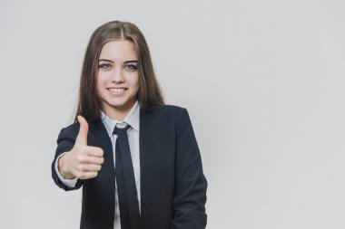 Kadın el hareketleri başparmak kadar. İş kızı geniş gülümsüyor ve olumlu duygular paylaşıyor.