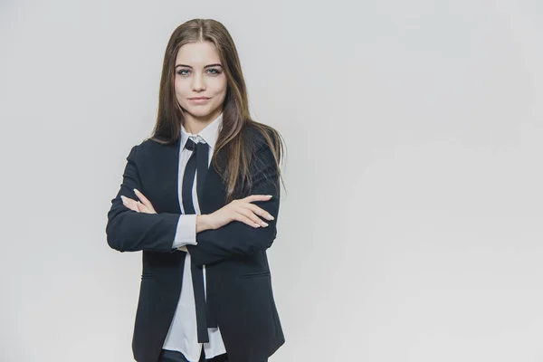 Charmosa empresária confiante está de pé sobre o fundo branco. Atraente feminino, o modelo profissional é isolado. Ela está sorrindo um pouco, cruzando suas mãos bem tratadas. Fecha. Entendido. — Fotografia de Stock