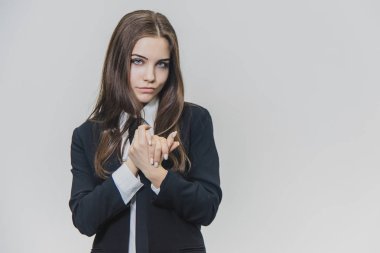 Ciddi düşünceli ve ince gülümsedi, kahverengi saçlı iş kadını birbirine yakın ellerini tutuyor ve onları çapraz yapıyor.