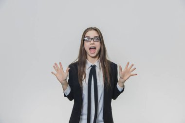 Başarılı kadın zaferinin iki elini de yaydığını, avuçlarını gösterdiğini haykırarak bağırıyor. İş kadını siyah jant ve mavi takım elbiseli glasees giyiyor.