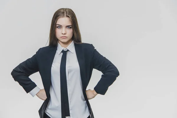 Hardwerkend mooi bruin harige vrouw kijkt serieus camera met haar armen Akimbo, is geïsoleerd, op de witte achtergrond. Ruimte kopiëren. — Stockfoto