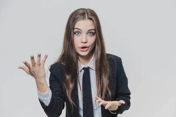 Young, attractive businesswoman is shocked and with blue round eyes, standing on the white background. Copy space. — Stock Photo, Image