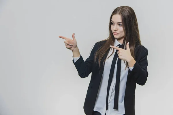 Young pretty, brown-haired businesswoman is pointing her point fingersto the right side with a curiuos facial expression. — Stock Photo, Image