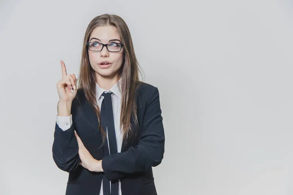 Young pretty businesswoman is pointing her finger up with an amusement, amazement and dazzling facial expression. — Stock Photo, Image