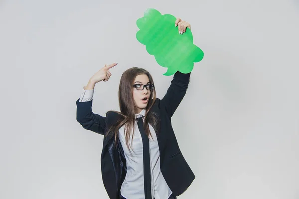 La jeune femme tient une bulle verte sur elle-même, qui est en forme de nuage, avec une main, isolée, sur le fond blanc. Adorable dame regarde bulle de discours avec surprise, pointant du doigt — Photo