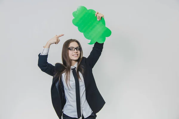 La jeune femme tient une bulle verte sur elle-même, qui est en forme de nuage, avec une main, isolée, sur le fond blanc. Jeune femme regarde la caméra souriant largement et pointe du doigt — Photo