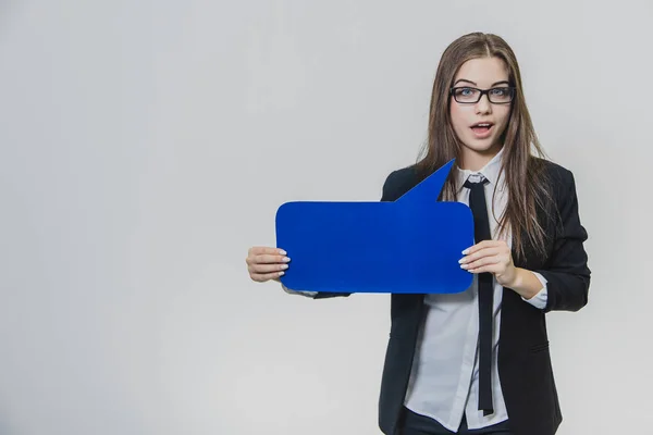 Jonge vrouw houdt een blauwe tekstballon voor zichzelf, die rechthoekig is, geïsoleerd, op de witte achtergrond. Jonge dame kijkt naar de camera met verrassing. Ze opent haar mond — Stockfoto