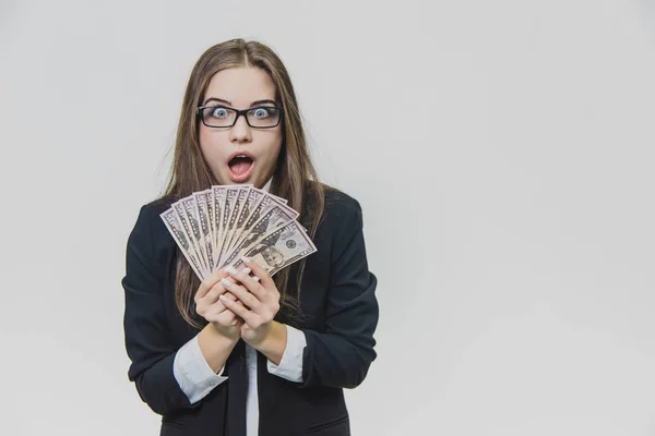 Joven empresaria conmocionada y emocionada está mostrando una pila de dinero, aislada sobre un fondo blanco. La chica tiene mucho dinero. Chica alegre está abriendo la boca, debido al asombro de tener dinero — Foto de Stock