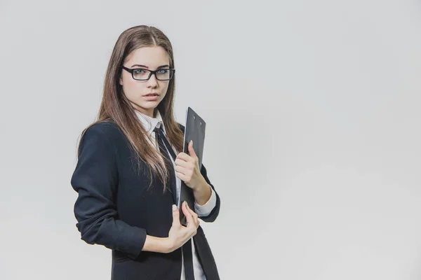 Aantrekkelijke Kaukasische zakenvrouw houdt zwarte papieren houder of Klembord met haar beide handen en kijkt kalm. — Stockfoto