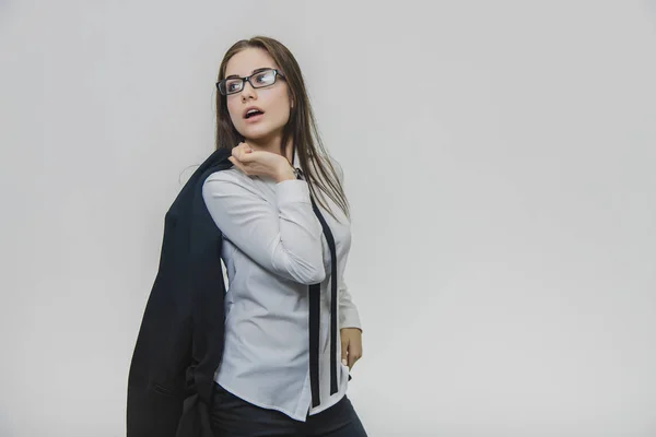 Mooie jonge zakenvrouw is het dragen van een bril en draagt een blauwe jas. Een zelfverzekerde vrouwelijke werkgever kijkt opzij. Meisje is druk. — Stockfoto