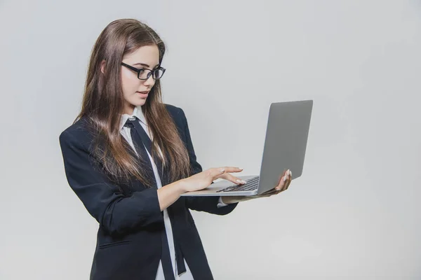 Beautiful young businesswoman is wearing glasses and using a modern computer touchscreen. Confident female employer is working and is concentrated. — Stock Photo, Image