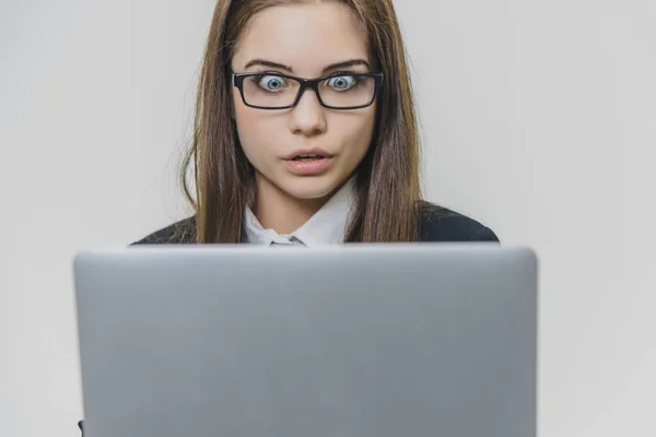 Hermosa joven empresaria está usando gafas y utilizando una moderna pantalla táctil de ordenador. La empleadora segura está trabajando y concentrada. La chica está mirando a la cámara. Siendo sorprendido ella es — Foto de Stock