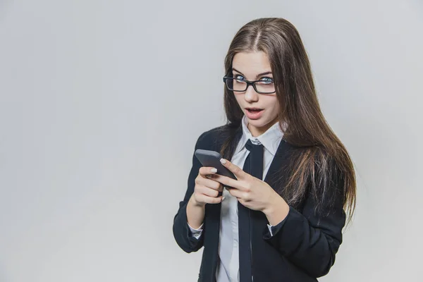 Charming caucasian business woman is holding phote and looking at it. She came up with an idea and immediately writes it down. — Stock Photo, Image