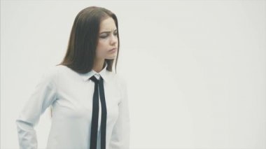 Beyaz bir arka plan üzerinde duran genç iş kızı. Bu esnada, o bir kenara bakar ve alnına elini koyar kız arkadaşı gibi görünüyor.