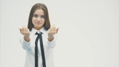 Genç kız beyaz bir arka plan üzerinde ayakta gülümsüyor. Bu süre zarfında, sınıfa yapılan bir çağrı bir jest gösterir ve el ele.