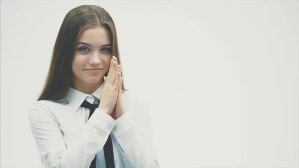 Young business girl standing on a white background. During this, he looks straight into the camera and trees in hand with an action plan. — Stock Video