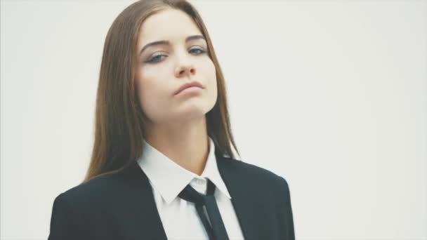 Jonge vrouw in zwart Business Suit staande op geïsoleerde witte achtergrond. — Stockvideo