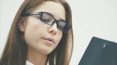 Beyaz bir arka plan üzerinde duran büyüleyici bir genç iş kızı.