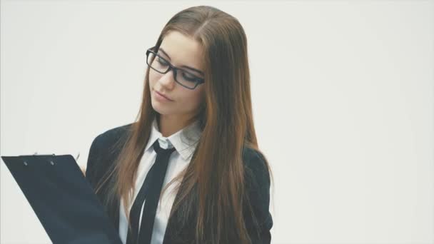 A business girl wearing a document folder and a friendly smile is standing on a white background. — Stock Video