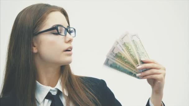 A cheerful surprised business woman looking at a camera while holding dollars in her hand, isolated over a white background. — Stock Video