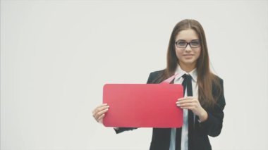 Genç iş kızı beyaz bir arka plan üzerinde duran ve siyah bir ceket giymiş.