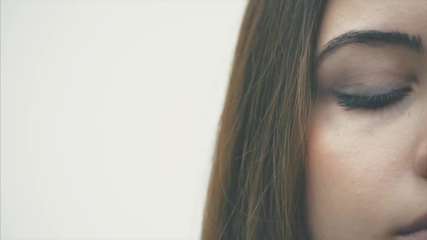 Atractiva joven mujer de negocios con ojos azules en gafas. Primer plano de un hermoso ojo de chicas. Tiene la piel limpia. Aislado sobre fondo blanco. Mociones lentas . — Vídeos de Stock