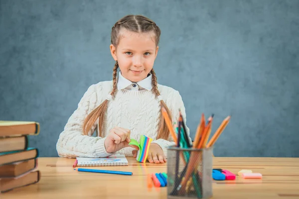 Neugieriges kleines Mädchen spielt mit Aufklebern, die in die Kamera schauen. — Stockfoto