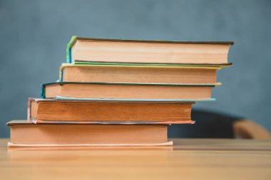 Farklı bir kitap yığını, Öğreticiler boş odada masada.