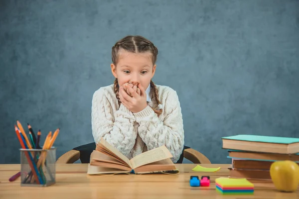 Porträt einer hübschen, netten Schülerin, die nicht an Worte glauben kann, geschrieben in dem Buch, das sie gerade liest. — Stockfoto