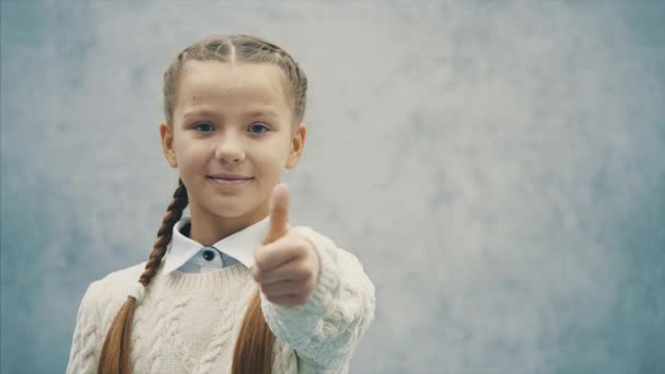 Geïsoleerde schoolmeisje wijst haar duim vinger omhoog. — Stockvideo