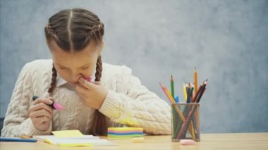 Küçük okul çocuk Marker ile etiket yazma sürecinde yer almaktadır.