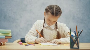 Yaratıcı okul çocuğu çizimi, sonra kalemlerin birini kutuya geri koyarak.