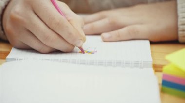 Onun Notebook pembe kalem ile çizim yaratıcı çocuk elleri.