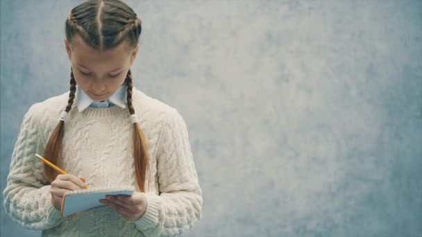 Isolerad Schoolgirl radera något i hennes skissblock. — Stockvideo