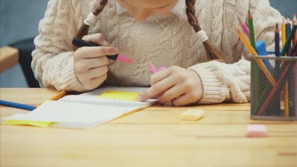 Kreative Schülerin zeichnet auf dem gelben Aufkleber mit einem rosa Textmarker. — Stockvideo
