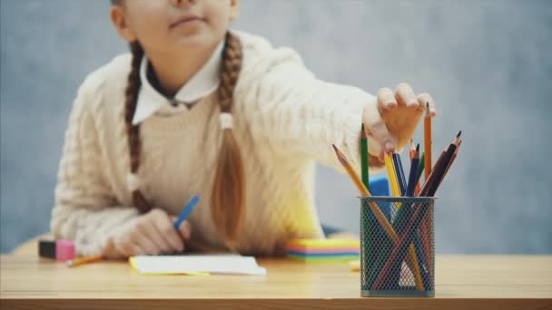 Изолированная школьница добирается до желтых карандашей и рисунков в альбоме . — стоковое видео
