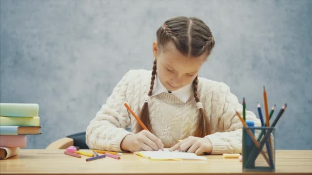 Creative schoolkid ritning, sedan sätta en av blyertspennor tillbaka in i lådan. — Stockvideo