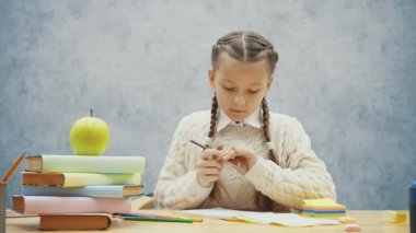 Kahverengi kalem kırılmış. Küçük kız onu keskinleştirmeye.