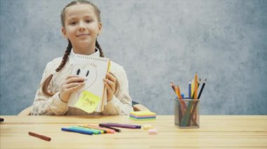 Okul çocuk gülümseyen kalp onun resmini gösteren, göz kırpıyor ve onun dilini gösteren.