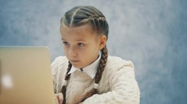 Güzel liseli yaygın açılan mavi gözleri ile Laptop bakıyor.