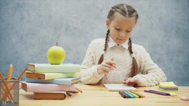 Schoolmeisje kiest Red Highlighter, opent het en begint met tekenen. — Stockvideo